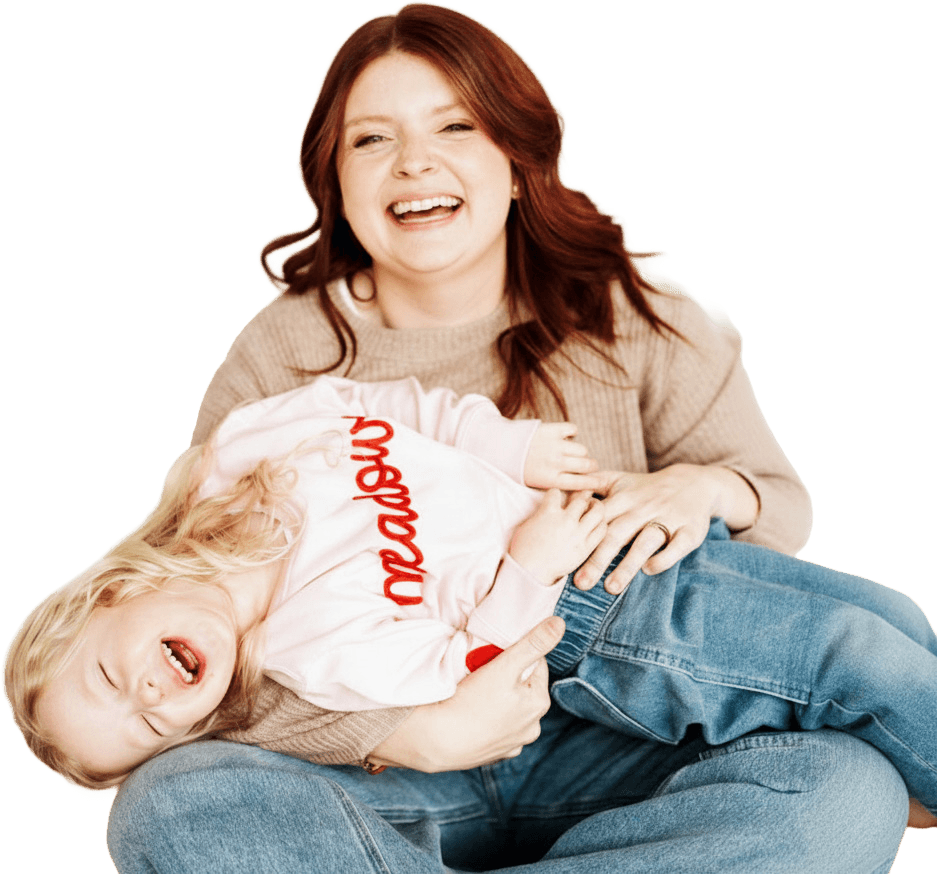 Sarah Boes laughing while holding her daughter Meadow
